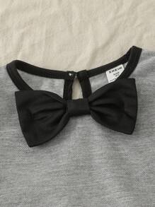 Maglietta girocollo per ragazze con fiocco, in stile semplice e femminile da college, abbinata a una gonna corta. Outfit da college e abbigliamento sportivo per il ritorno a scuola della stagione 2025