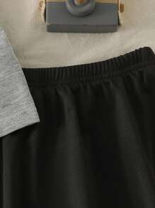 Maglietta girocollo per ragazze con fiocco, in stile semplice e femminile da college, abbinata a una gonna corta. Outfit da college e abbigliamento sportivo per il ritorno a scuola della stagione 2025