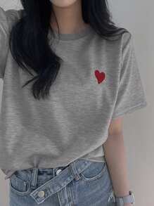 DAZY Camiseta gráfica minimalista para mujer con cuello redondo, bordado y contraste de color en forma de corazón