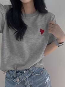 DAZY Camiseta gráfica minimalista para mujer con cuello redondo, bordado y contraste de color en forma de corazón