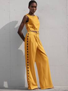 Aveloria Modichic Nouvel ensemble deux pièces femme de style français comprenant un top court sans manches avec col rond, à cordon de serrage, design sophistiqué avec broderie losange évidée, en coloris unicolore, et un pantalon large et droit. Tenue élégante et minimaliste pour les vacances.