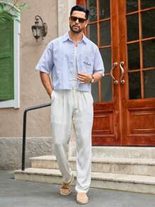 HIMLAND Camisa de manga corta con bolsillo de bordado de letra, de tela tejida y de corte holgado, para hombre, de estilo casual