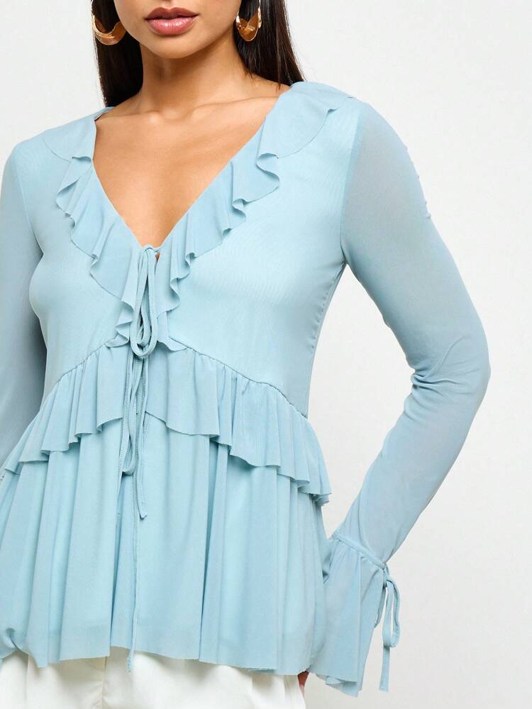 ボヘミアン風ペザントブラウス。フロントのフリルとロングベルスリーブが特徴。