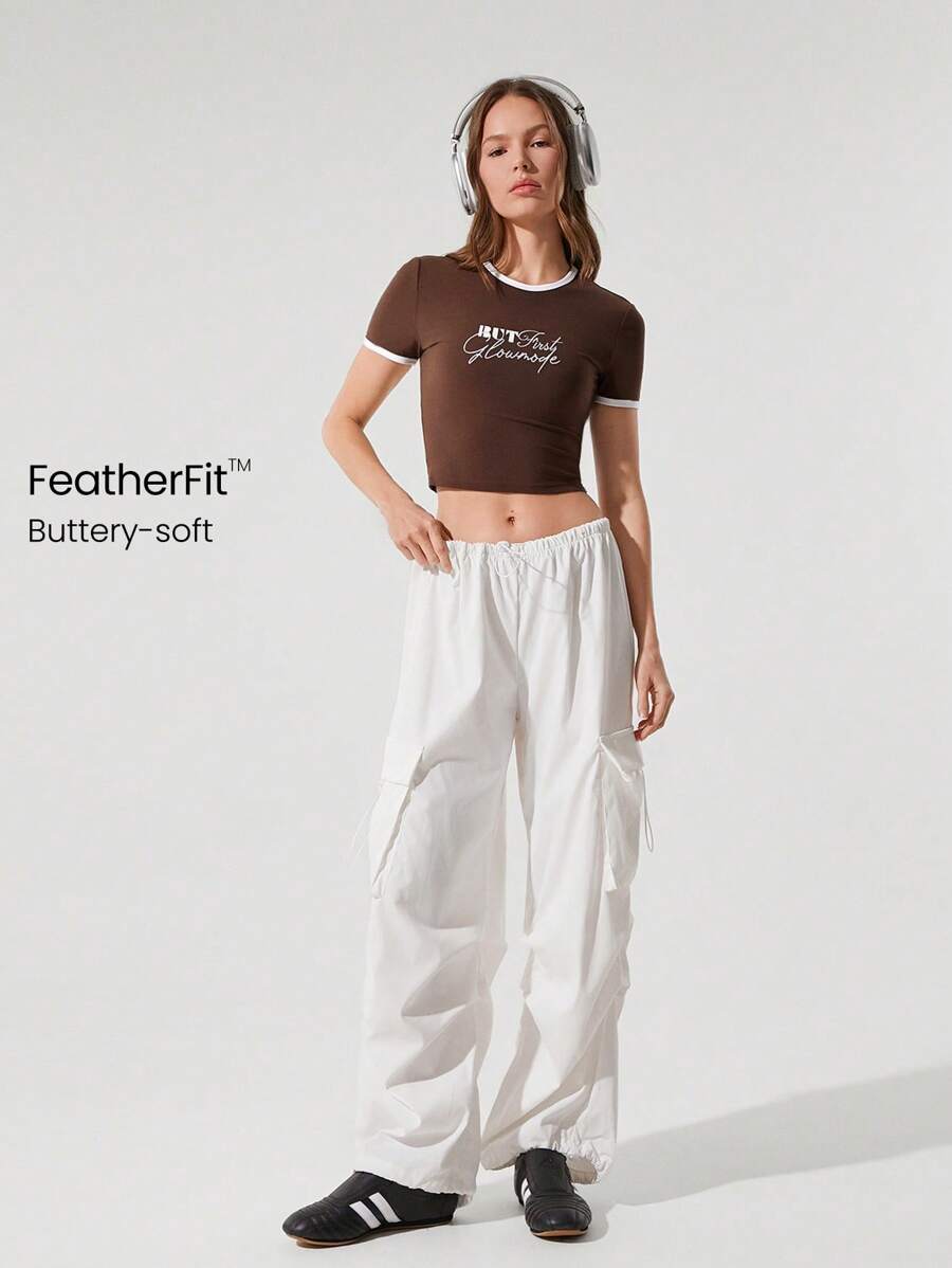 GLOWMODE Camiseta corta de manga corta y cuello redondo con gráfico de FeatherFit™ Oh Baby. Parte superior corta apta para yoga, pilates, barre y uso casual diario de bajo impacto - Marrón - Ver 1
