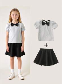 Maglietta girocollo per ragazze con fiocco, in stile semplice e femminile da college, abbinata a una gonna corta. Outfit da college e abbigliamento sportivo per il ritorno a scuola della stagione 2025