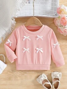 SHEIN Effen sweatshirt met ronde hals en strik voor babymeisjes. Het ronde halsontwerp is klassiek en elegant, waardoor het gemakkelijk aan en uit te trekken is. De lange mouwen en de decoratieve 3D-strik op het lijfje combineren vakkundig de schattige en modieuze elementen, waardoor de levendigheid en speelsheid van het meisje worden benadrukt. Het getailleerde silhouet en de vloeiende lijnen flatteren het figuur van de baby en stralen zelfvertrouwen en geluk uit. Dit sweatshirt is geschikt voor diverse gelegenheden.