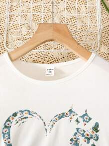 SHEIN Set de 2 piezas para adolescentes que incluye: Camiseta de manga corta y cuello redondo con corazón tejido y estampado floral, y mini falda verde con estampado floral dulce. Adecuado para vacaciones, días festivos, almuerzos, festivales de música y uso al aire libre.