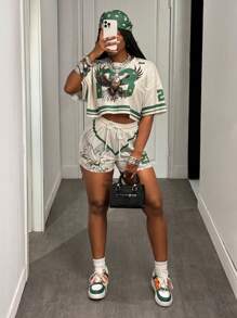 Slaydiva Conjunto deportivo informal de verano 2025 estilo universitario retro: Camiseta de cuello redondo de manga corta con estampado digital de águila 23 y rayas verdes + Pantalón corto estampado con alas y dígitos 23 en color albaricoque, conjunto holgado de dos piezas para mujer