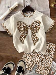 SHEIN Bộ 2 món/bộ trang trí nơ họa tiết da báo Mỹ phong cách cổ điển thường ngày cho bé gái, bộ áo tay ngắn và quần đùi, phù hợp với mùa hè, thời trang thập niên 80, màu Mocha Harmony, thể thao, sẵn sàng cho lễ tốt nghiệp, trẻ em vui vẻ - Nhiều màu - Xem 2