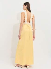 Nöista 这款奶油黄色缎面连衣裙，饰有精致蕾丝花边，后背配有吊带。柔和的光泽和浪漫的领口带来复古迷人的气息，非常适合约会之夜或日落度假。