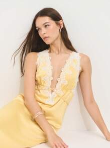 Nöista 这款奶油黄色缎面连衣裙，饰有精致蕾丝花边，后背配有吊带。柔和的光泽和浪漫的领口带来复古迷人的气息，非常适合约会之夜或日落度假。