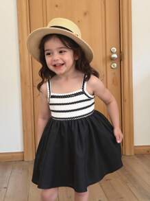 SHEIN Playful Pals 女婴休闲吊带A字裙。这款连衣裙采用吊带设计，简约优雅。A字廓形散发着活泼可爱的气息。宽松版型适合所有体型的宝宝。它非常适合海滩旅行、户外野餐等夏季活动，也适合休闲的室内穿着，让宝宝在享受无忧无虑的时光的同时，展现独特的魅力。 - 黑與白 - 查看 5