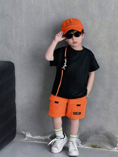 2件套男童时尚休闲圆领T恤和荧光绿工装短裤套装，适合春夏季日常穿着、运动、户外、上学、聚会、度假、拍照等场合。男童橙色套装，男童橙色短裤套装，男童休闲短裤套装，男童夏季服装短裤套装。