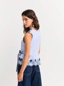 Nöista Sleeveless Wrap Blouse With Floral Embroidery And Scalloped Edges. Peplum Hem, Feminine Silhouette, Elegant, Lace-Style Details, Adjustable Tie Waist, Lightweight, Perfect For Spring, Summer, Or Casual-Chic Looks. - Blue and White - View 2
