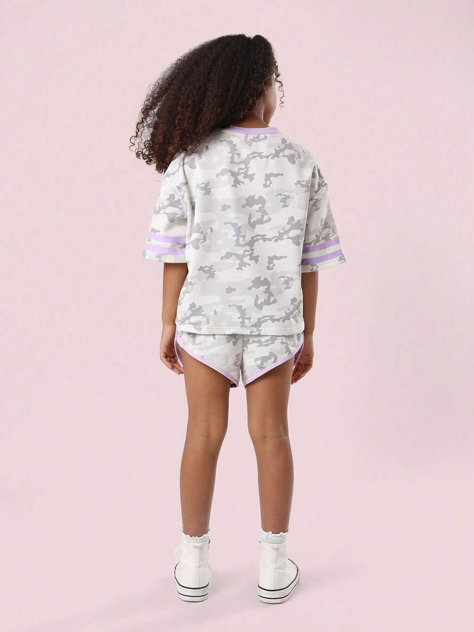 Camiseta e shorts camuflados com número universitário