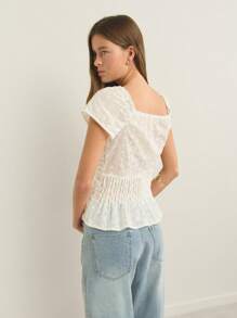 Nöista Blusa com decote quadrado, modelagem peplum e tecido texturizado com detalhes em renda, além de amarração; design leve e respirável, perfeito para praia, looks casuais para celebrações do Orgulho LGBTQIA+ e aeroporto; peça versátil para o verão. - Branco - Ver 2