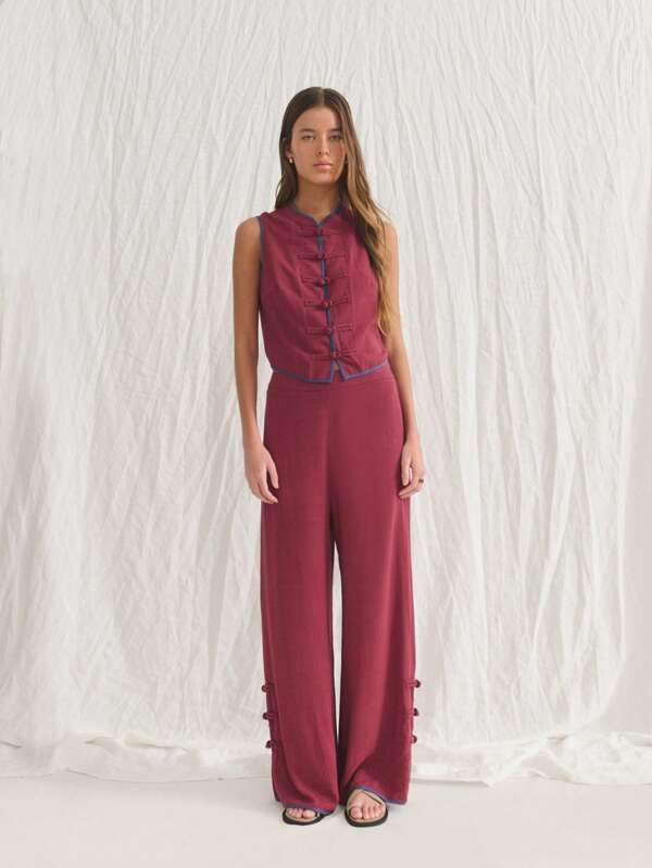 Nöista Conjunto de dos piezas sin mangas color granate con cuello Mao y botones tradicionales de nudos. Pantalones de pierna recta con detalles de botones. Elaborado con tela texturizada y transpirable. Elegante, estiloso, cómodo y versátil. Perfecto para looks casuales de vacaciones en la playa, atuendo para el aeropuerto o para el 4 de julio.