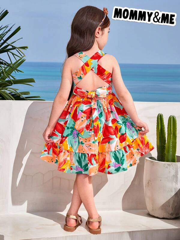 SHEIN Vestido corto de niña con estampado de plantas tropicales trenzadas, decoración de lazo y cintura elástica, estilo de vacaciones con estampado, vestido de tirantes finos, para verano y vacaciones en la playa. Combinable madre-hija y hermanas, estilo familiar a juego para vacaciones y días festivos.