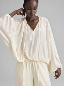 Ontre Áo thun nữ giáo viên thiết kế mới 2025 Ngày Độc lập, mặc thường ngày tại sân bay, chất liệu vải lanh thoải mái, cổ tròn, tay dài, thiết kế thắt nút, thắt eo, bo thun, dáng rộng, mặc hàng ngày, xuân/hè - Màu be - Xem 8