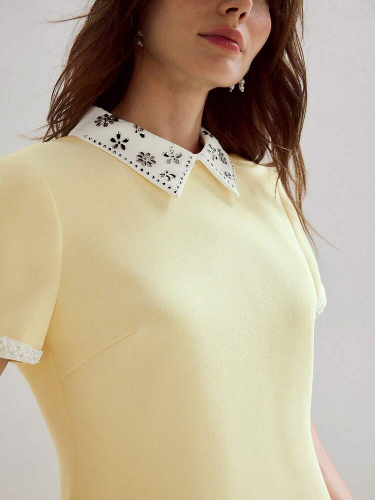 Vestido mini con cremallera en la espalda, cuello y puños de contraste con strass y perlas falsas