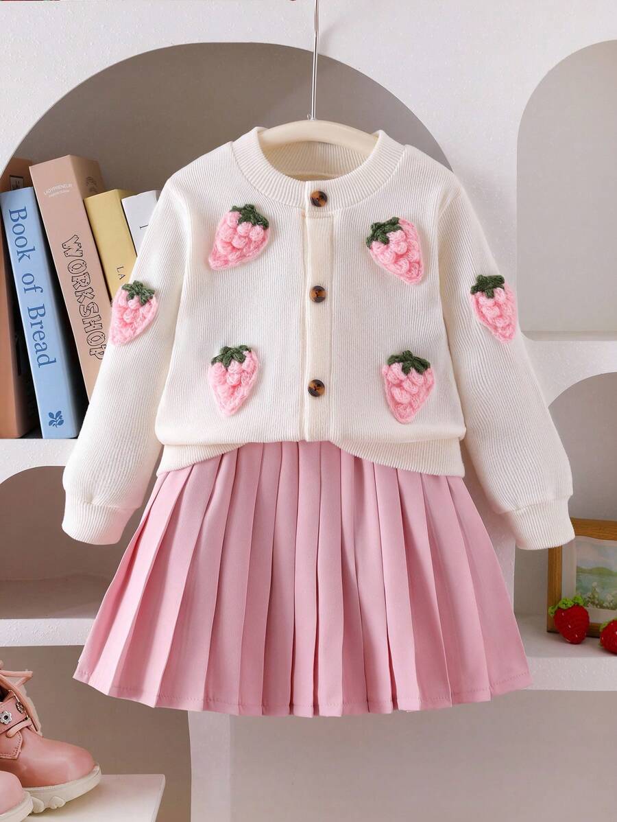 SHEIN 少女通勤可爱3D草莓开衫和百褶裙套装。这款针织毛衣采用鲜艳的草莓刺绣设计，搭配柔软的针织面料，时尚舒适，适合秋冬季节穿着。搭配的粉色百褶裙采用经典设计，自然垂坠的下摆，展现甜美优雅的风格。柔软的材质确保舒适的穿着体验。 - 粉色 - 查看 1