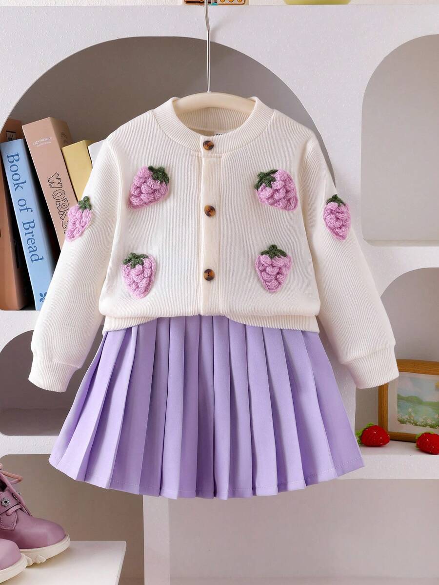 SHEIN 少女通勤款可爱3D草莓开衫搭配紫色百褶裙。这款针织毛衣采用鲜艳的草莓刺绣设计，搭配柔软的针织面料，兼具时尚与舒适。非常适合秋冬造型。搭配经典的紫色百褶裙，裙摆自然垂坠，展现甜美优雅的气质。柔软的面料确保舒适的穿着体验。