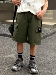 SHEIN Nuevos pantalones cortos anchos con parches para niños dinámicos de primavera y verano, hechos de tela suave y ligera, con bolsillos laterales prácticos, versátiles para ir y venir, trotar, jugar, ir a la escuela, eventos y fiestas - Verde militar - Ver 1