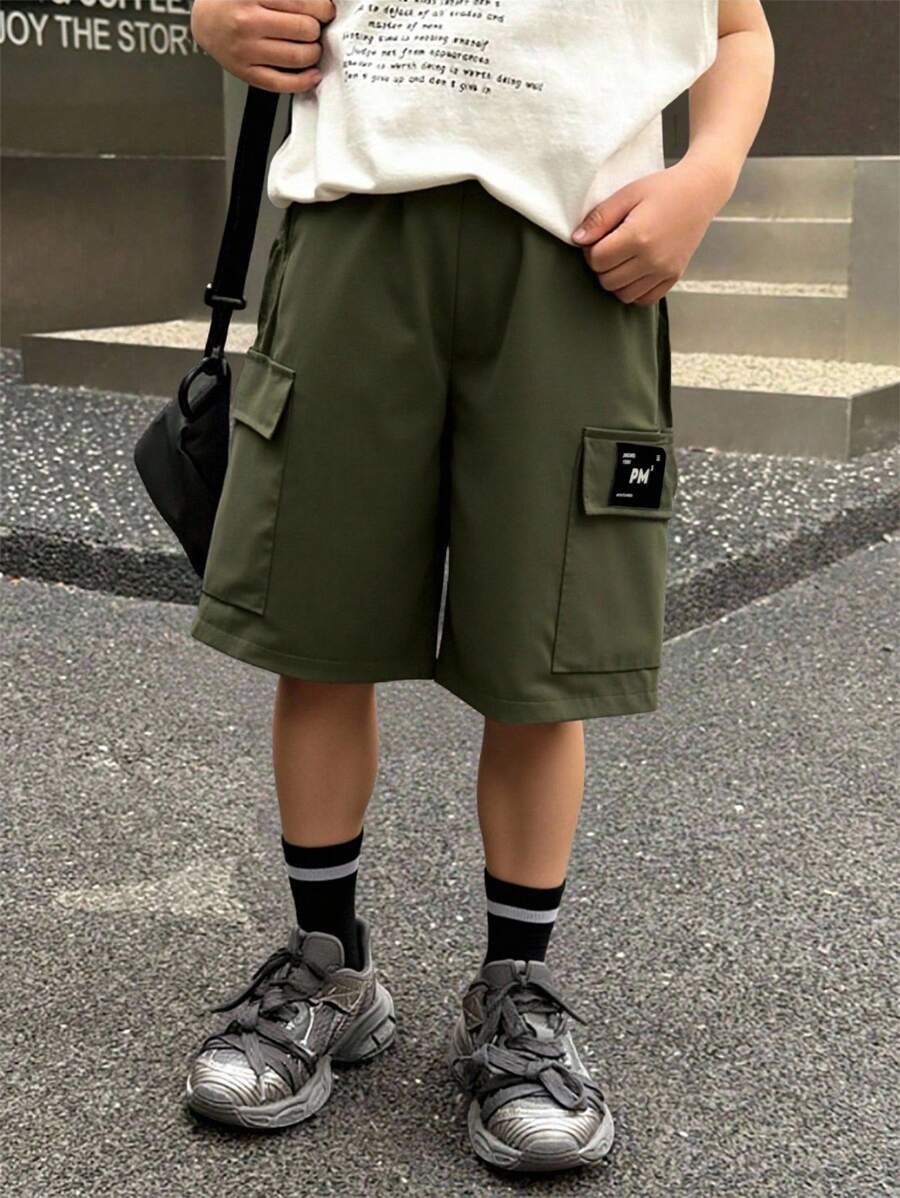 SHEIN Nuevos pantalones cortos anchos con parches para niños dinámicos de primavera y verano, hechos de tela suave y ligera, con bolsillos laterales prácticos, versátiles para ir y venir, trotar, jugar, ir a la escuela, eventos y fiestas - Verde militar - Ver 1