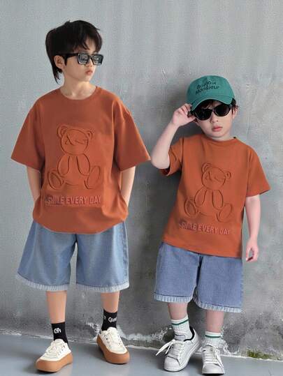 SHEIN مجموعة قميص كنزة بأكمام قصيرة فضفاضة وشورت جينز مريحة للأطفال والمراهقين الصبية، مناسبة لملابس العودة إلى المدرسة، قطعتان