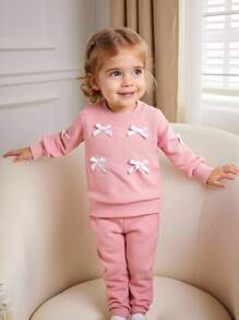 SHEIN Effen sweatshirt met ronde hals en strik voor babymeisjes. Het ronde halsontwerp is klassiek en elegant, waardoor het gemakkelijk aan en uit te trekken is. De lange mouwen en de decoratieve 3D-strik op het lijfje combineren vakkundig de schattige en modieuze elementen, waardoor de levendigheid en speelsheid van het meisje worden benadrukt. Het getailleerde silhouet en de vloeiende lijnen flatteren het figuur van de baby en stralen zelfvertrouwen en geluk uit. Dit sweatshirt is geschikt voor diverse gelegenheden.