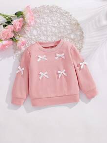 SHEIN Effen sweatshirt met ronde hals en strik voor babymeisjes. Het ronde halsontwerp is klassiek en elegant, waardoor het gemakkelijk aan en uit te trekken is. De lange mouwen en de decoratieve 3D-strik op het lijfje combineren vakkundig de schattige en modieuze elementen, waardoor de levendigheid en speelsheid van het meisje worden benadrukt. Het getailleerde silhouet en de vloeiende lijnen flatteren het figuur van de baby en stralen zelfvertrouwen en geluk uit. Dit sweatshirt is geschikt voor diverse gelegenheden.