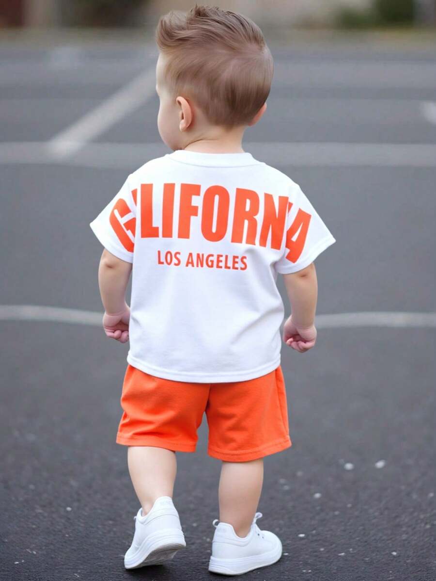 SHEIN Set de 2 piezas de ropa informal deportiva para niño/niña, estilo urbano con estampado de letras, que incluye una camiseta holgada de punto de cuello redondo y unos pantalones cortos de cintura elástica, apta para usar en primavera/verano tanto en casa como al aire libre