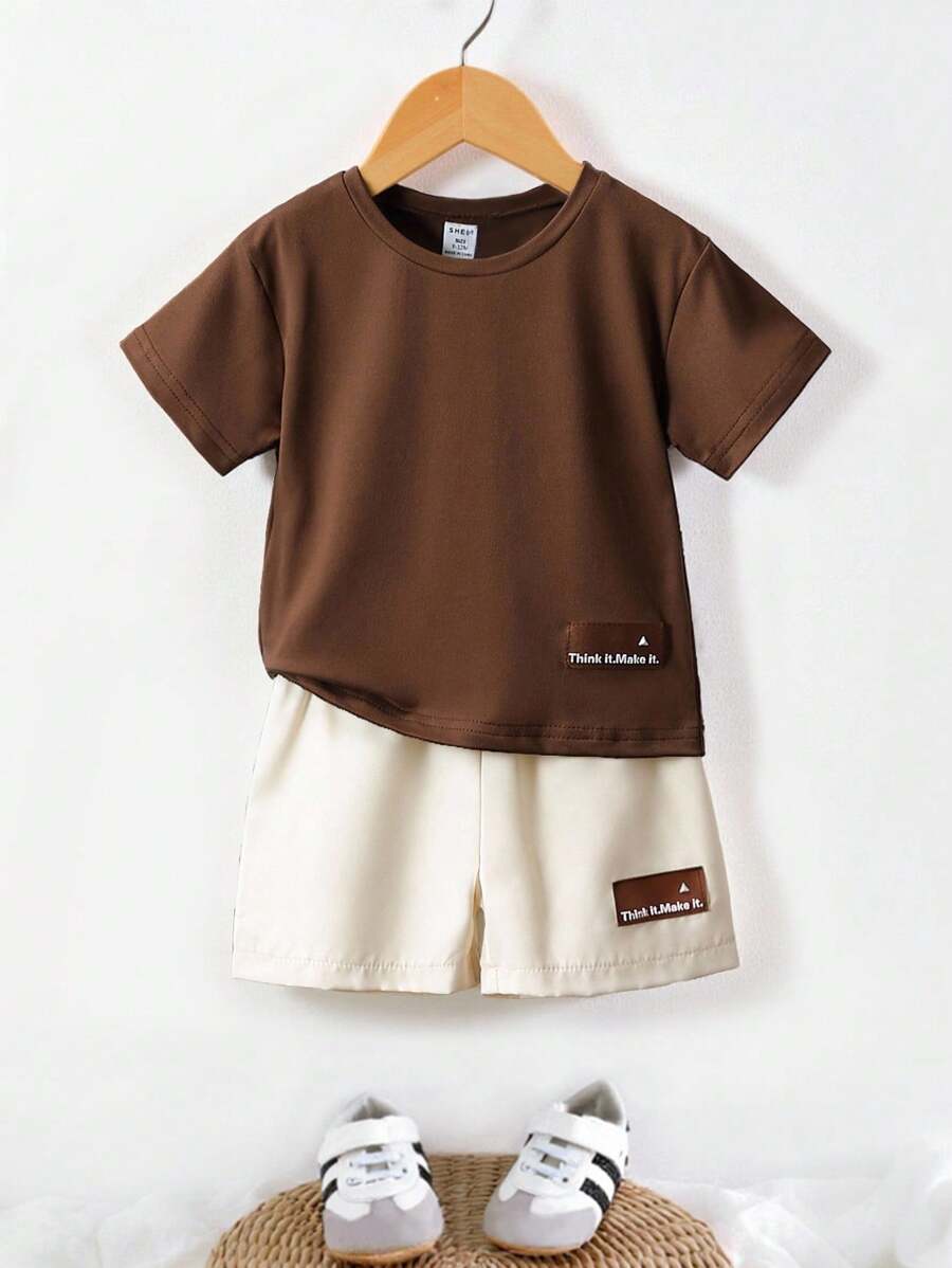 SHEIN 2 Pieces Baby Boy Unisex Newborn Neutral Set. It's A Set With A Brown Top And Apricot Shorts, Decorated With Letter Patches. Suitable For Summer, This Sportswear Is Perfect For Vacations, Parties, Outings, And As A Versatile Basic For School In Summer.Outfit Toddler Infant Outfits Unisex Summer. - Brown - View 1