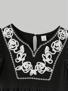 Ontre 这款舒适的黑色棉混纺中长连衣裙专为少女设计，采用时尚的V领和可爱的荷叶边袖口。这款休闲连衣裙还饰有优雅的白色花卉刺绣细节。