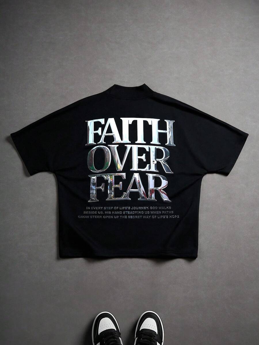 Manfinity Roghcode 男士年轻街头服饰，INS 风格搭配高街金属酸洗字体设计，黑色短袖 T 恤上印有超大字母图案，宽松版型，略带蝙蝠袖，小立领设计。适合街头运动、音乐节和日常穿着，是送给男朋友或老公的绝佳礼物。它体现了街头时尚和 Y2K 风格。男士图案 T 恤，超大图案 T 恤。男士休闲标语印花短袖 T 恤，夏季，Faith Over Fear 衬衫，男士图案 T 恤，男士标语 T 恤 - 黑色 - 查看 1