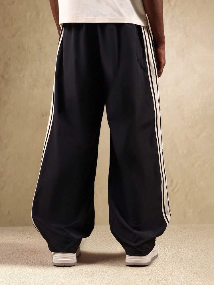 Pantalon de survêtement à jambes larges avec bandes latérales