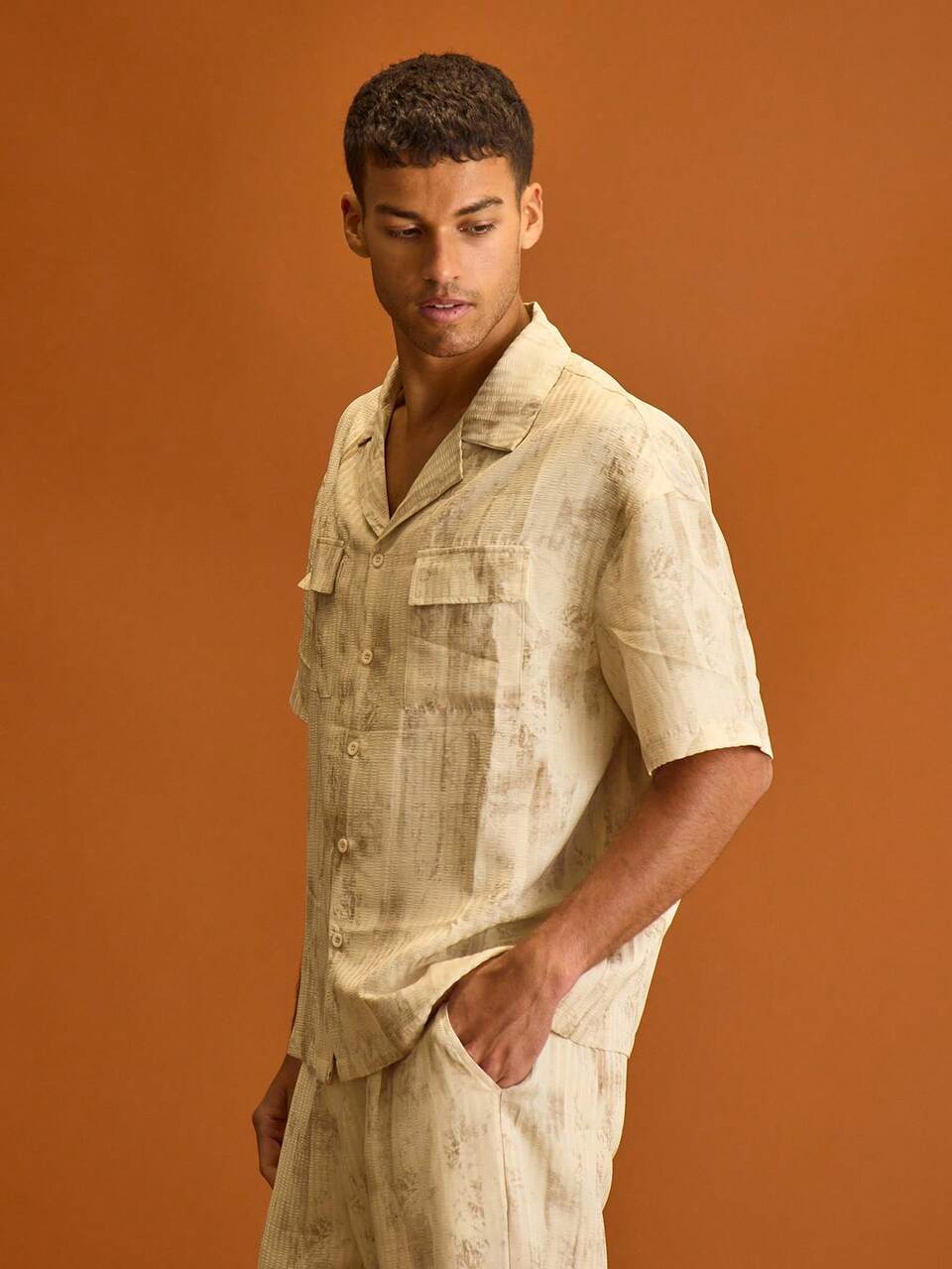 Chemise à manches courtes à boutons avec poche avant, col châle, motif délavé sur tout le vêtement. Idéale pour le printemps et l'été, les vacances
