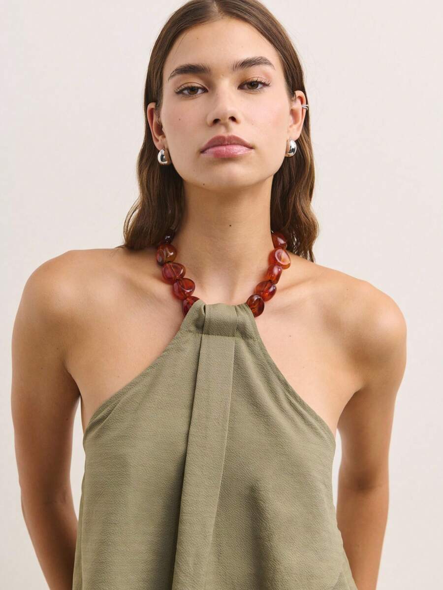 Nöista 这款无袖吊带上衣采用柔和的橄榄绿色，正面垂褶设计搭配木珠领口，营造出轻松飘逸的廓形。是夏季的理想之选。 - 軍綠色 - 查看 1