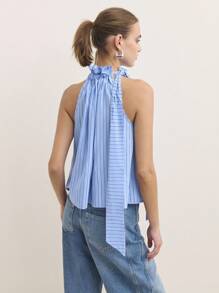 Nöista Fai una dichiarazione con questa blusa blu, realizzata con un collo arricciato e un fiocco drammatico su una spalla. Perfetta per i vestiti da donna autunnali, il casual business o i vestiti da scuola. Il suo design elegante e unico si adatta perfettamente dall'abbigliamento da ufficio per le donne agli eventi speciali autunnali o agli outfit per uscire.