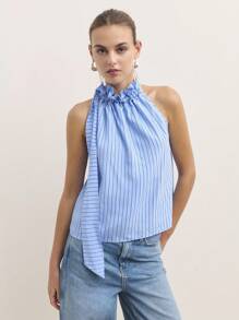 Nöista Fai una dichiarazione con questa blusa blu, realizzata con un collo arricciato e un fiocco drammatico su una spalla. Perfetta per i vestiti da donna autunnali, il casual business o i vestiti da scuola. Il suo design elegante e unico si adatta perfettamente dall'abbigliamento da ufficio per le donne agli eventi speciali autunnali o agli outfit per uscire.