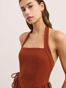 Nöista 这款铁锈色迷你连衣裙采用挂脖式领口，廓形修身喇叭形，侧面饰有精致系带。复古风格的设计和鲜艳的色调，使其成为夏季场合的完美之选，充满俏皮感。