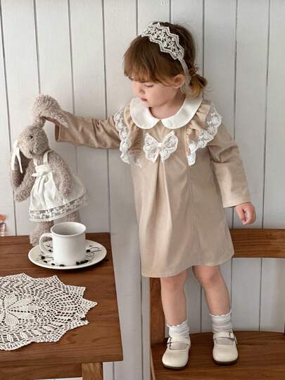 SHEIN 这款女婴春秋季甜美时尚休闲连衣裙，饰有荷叶边、白色蕾丝、彼得潘领和长袖，卡其色，是日常穿着的必备单品。
