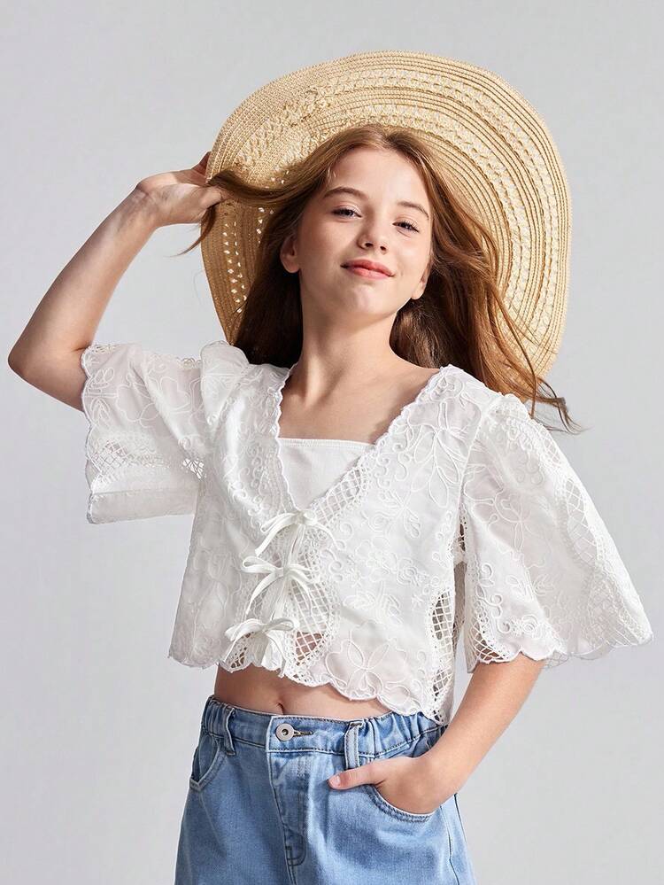 Adorable White Eyelet Cropped Top For Kids, Featuring A Sweet V-Neckline With Bow Tied Lace-Up Front And Scalloped Edges, Ideal As Stylish Summer Beachwear.