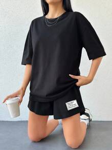 ZIRRA Bộ 2 món áo thun cổ tròn trễ vai màu trơn kèm quần short cạp chun in chữ thường ngày cho nữ - màu đen - Xem 4