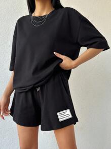 ZIRRA Bộ 2 món áo thun cổ tròn trễ vai màu trơn kèm quần short cạp chun in chữ thường ngày cho nữ - màu đen - Xem 5