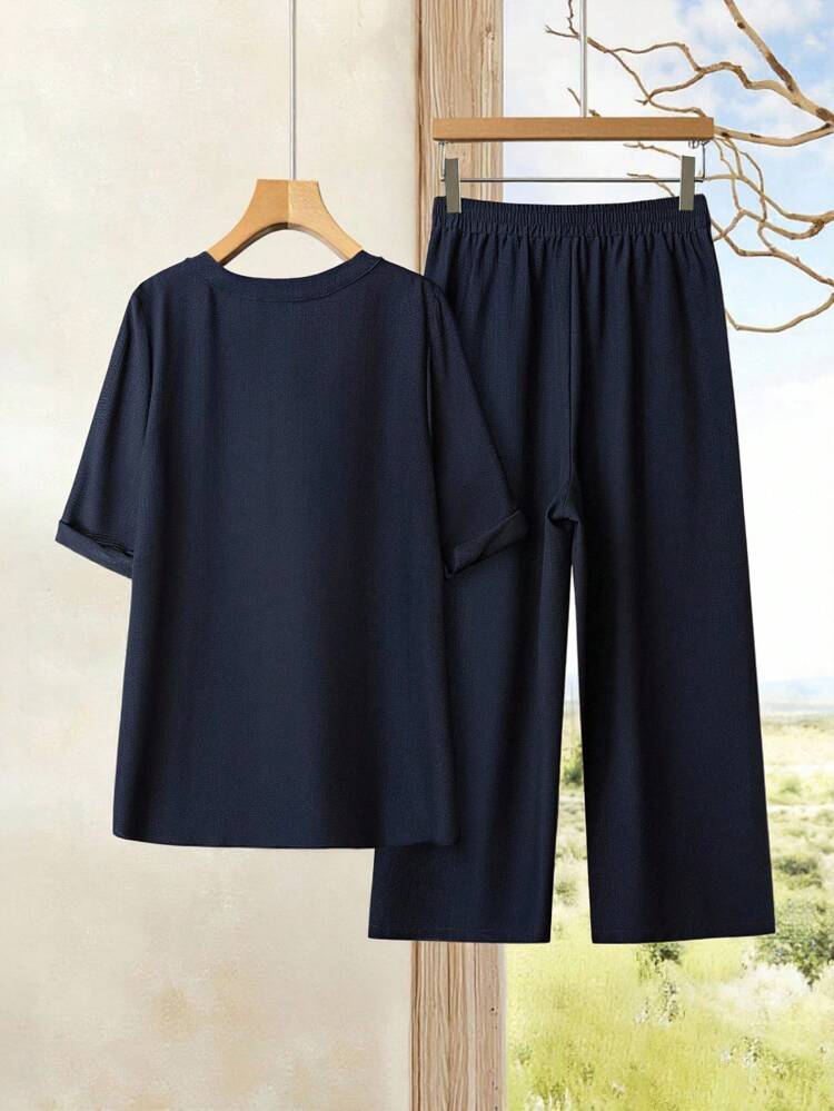 Conjunto de dos piezas sueltas y casuales para mujer de talla grande en verano de una camisa de manga enrollada de cuello en V con muescas y un pantalón de pierna ancha de unicolor