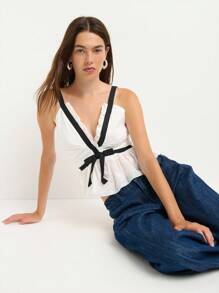 Nöista 这款白色荷叶边吊带背心，优雅又不失女性魅力，黑色荷叶边和蝴蝶结装饰更添亮点。无论是返校节、派对，还是作为秋季时尚女装，都是理想之选——无论是开学季还是约会之夜，都能让你成为众人瞩目的焦点。 - 白色 - 查看 1