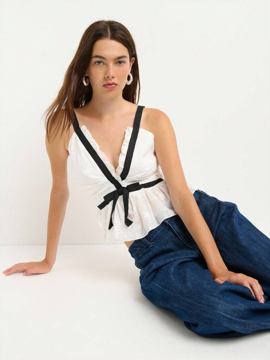 Nöista 这款白色荷叶边吊带背心，优雅又不失女性魅力，黑色荷叶边和蝴蝶结装饰更添亮点。无论是返校节、派对，还是作为秋季时尚女装，都是理想之选——无论是开学季还是约会之夜，都能让你成为众人瞩目的焦点。 - 白色 - 查看 1