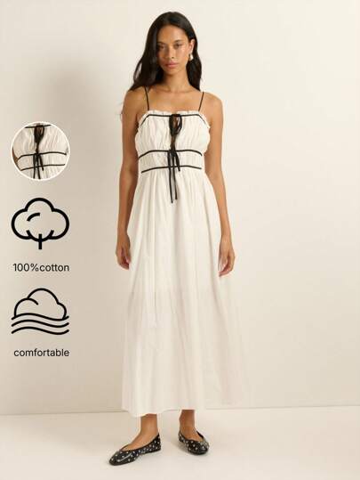 Nöista 这款白色长裙采用黑色滚边、可调节细肩带和收紧高腰设计，打造复古优雅的轮廓，非常适合秋季、冬季、街头服饰、Y2K 和老派金钱风格的女性。