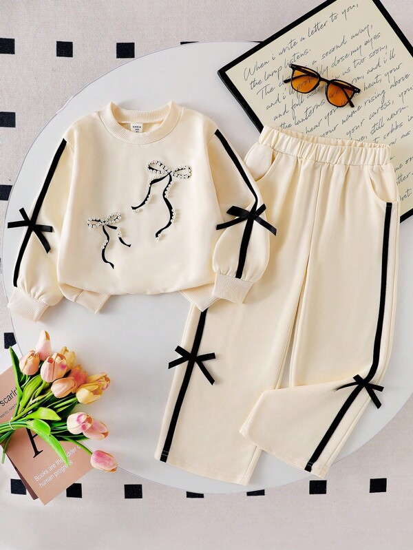 Genkimix Kids Conjunto de sudadera de cuello redondo con lazo de cinta color albaricoque y pantalones rectos para niñas, con diseño delicado con perlas, bolsillos, para niñas, conjunto de manga larga, conjuntos de manga larga para niñas, conjunto de sudadera de manga larga para niñas en otoño e invierno